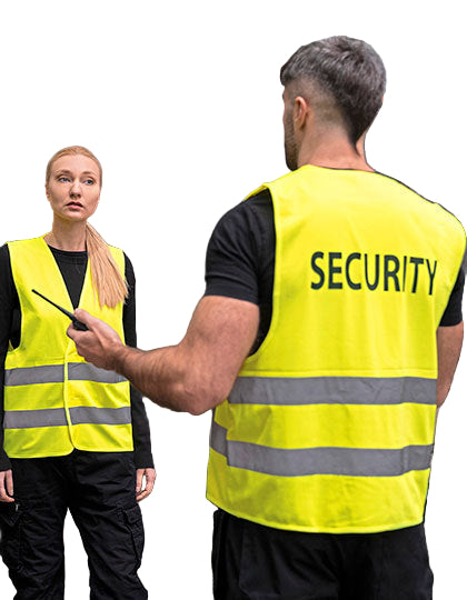 Twee beveiligingsmedewerkers dragen gele veiligheidsvesten met reflecterende strepen en het opschrift ‘Security’, in een industriële omgeving.